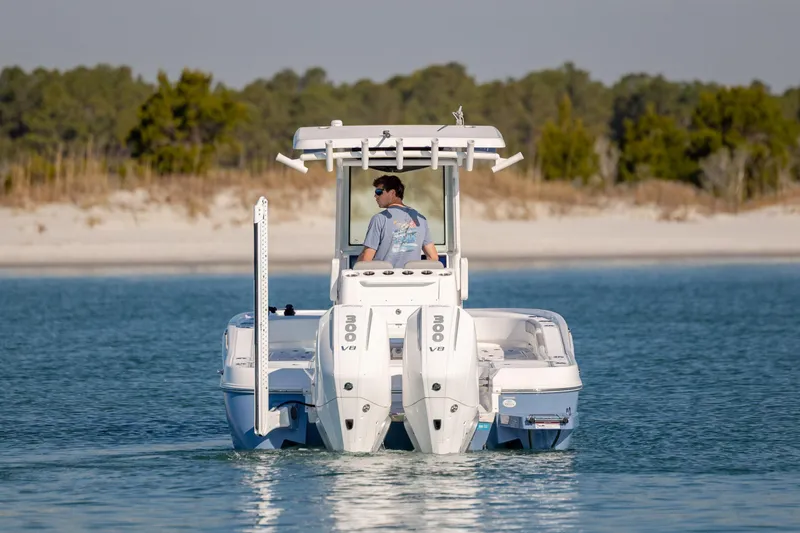 Slide: The Image of 2024 Caymas 281 HB boat cruising on calm water near a sandy shoreline. - 9