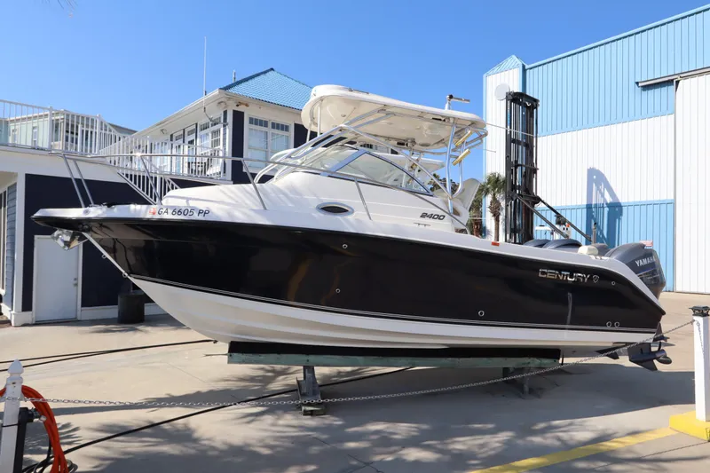 Slide: The Image of 2009 Century 2400 Walk-Around boat displayed outdoors on a sunny day. - 2