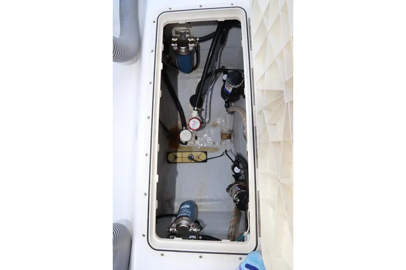 Slide: The Image of 2009 Century 2400 Walk-Around boat compartment with pumps and hoses. - 21