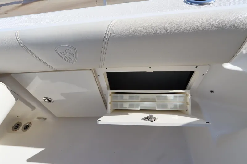 Slide: The Image of 2009 Century 2400 Walk-Around boat storage compartment with open hatch and organizer trays. - 35