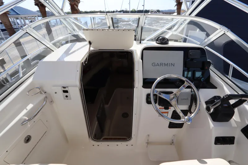Slide: The Image of 2009 Century 2400 Walk-Around boat cockpit with Garmin navigation system and steering wheel. - 48