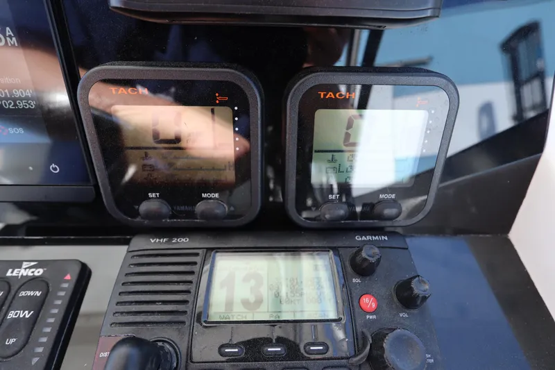 Slide: The Image of Dashboard of a 2009 Century 2400 Walk-Around boat with tachometers and Garmin VHF radio. - 53