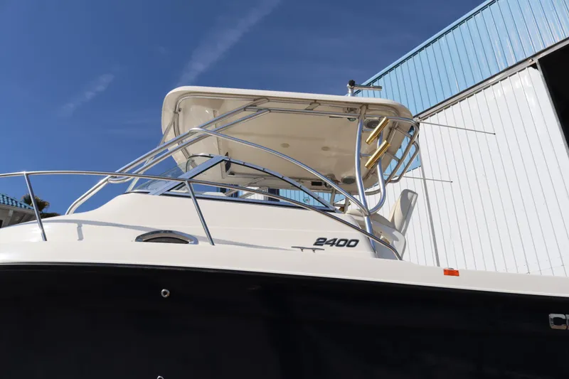 Slide: The Image of 2009 Century 2400 Walk-Around boat with sleek design, docked under clear blue sky. - 6