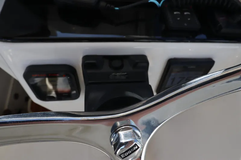 Slide: The Image of 2009 Century 2400 Walk-Around boat dashboard with steering wheel and controls. - 60