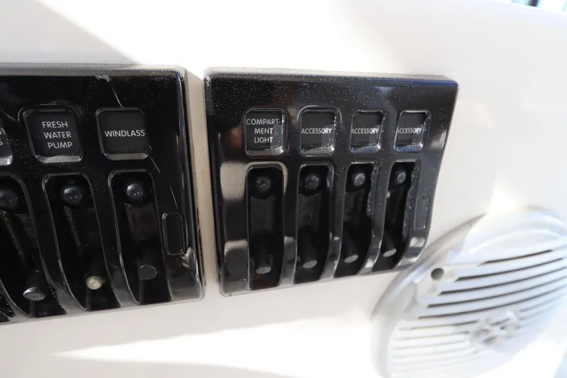 Slide: The Image of Control panel of a 2009 Century 2400 Walk-Around boat with labeled switches. - 62