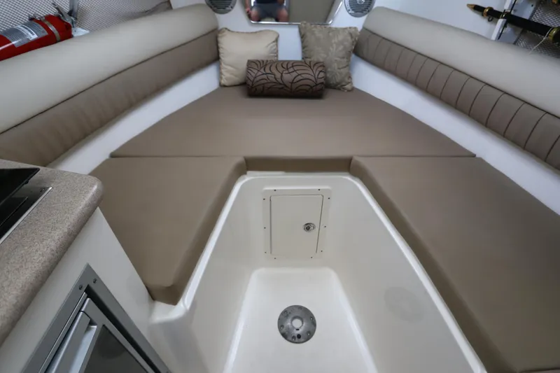 Slide: The Image of 2009 Century 2400 Walk-Around cabin interior with beige cushions and storage compartment. - 66