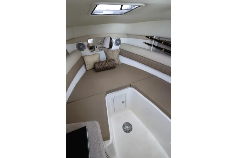 Slide: The Image of 2009 Century 2400 Walk-Around cabin interior with cushions and fishing rod storage. - 67