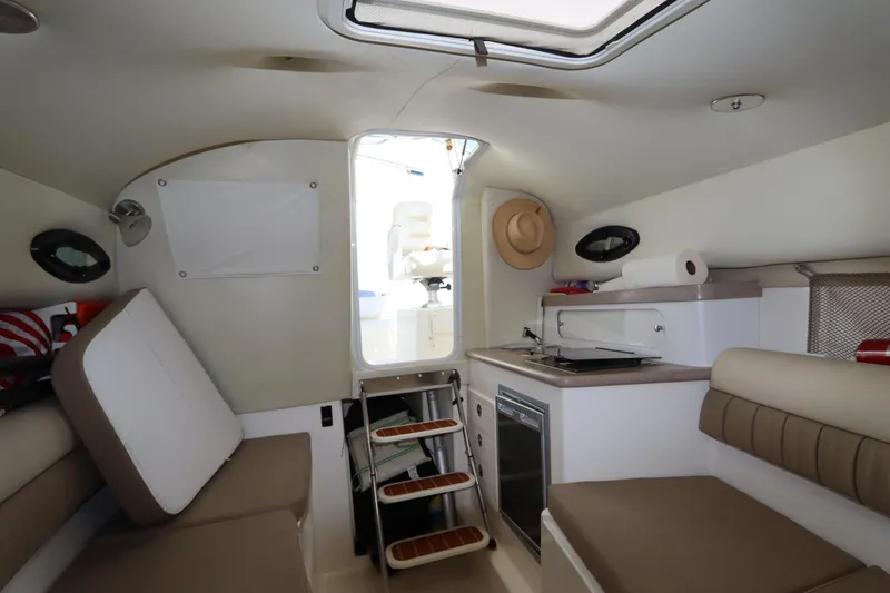 Slide: The Image of Interior of a 2009 Century 2400 Walk-Around boat with seating and kitchenette. - 68