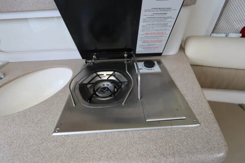 Slide: The Image of 2009 Century 2400 Walk-Around boat interior with stove and sink. - 70