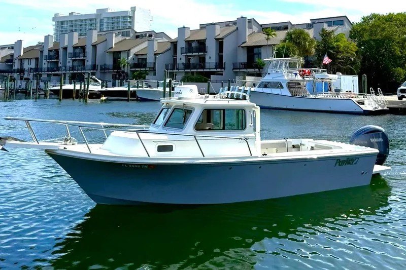 The Image of 2023 Parker 2320 Sport Cabin boat on water, with modern buildings in background. - 0