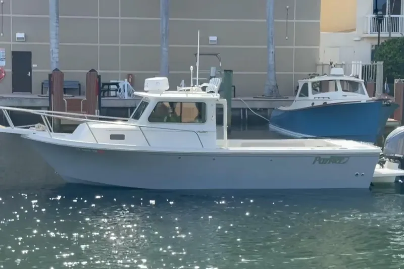 Slide: The Image of 2023 Parker 2320 Sport Cabin boat docked in a marina. - 1