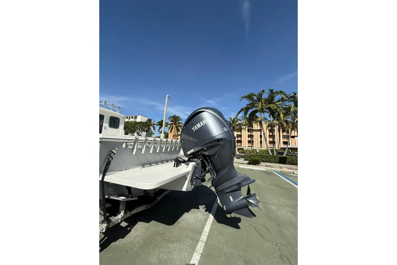 Slide: The Image of 2023 Parker 2320 Sport Cabin with Yamaha outboard motor in a sunny parking lot. - 12