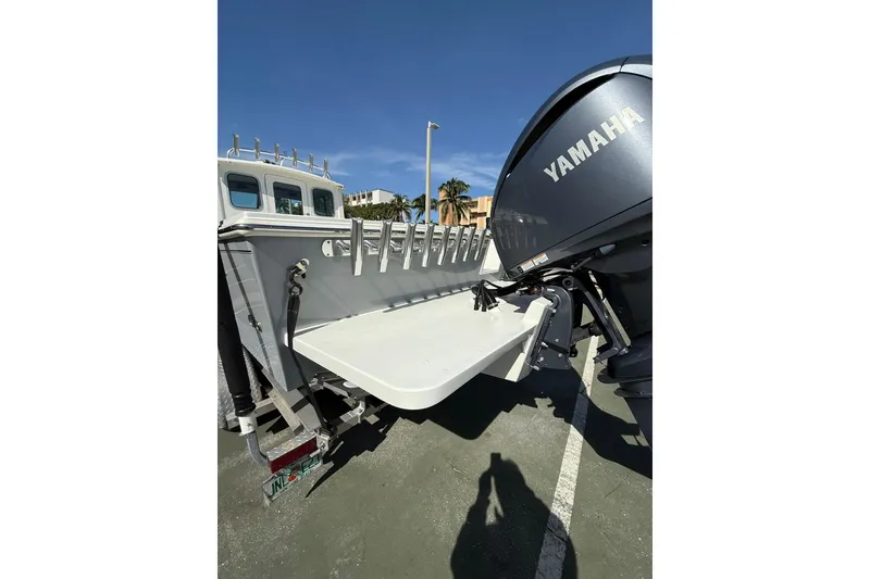 Slide: The Image of 2023 Parker 2320 Sport Cabin boat with Yamaha engine, docked under clear blue sky. - 14