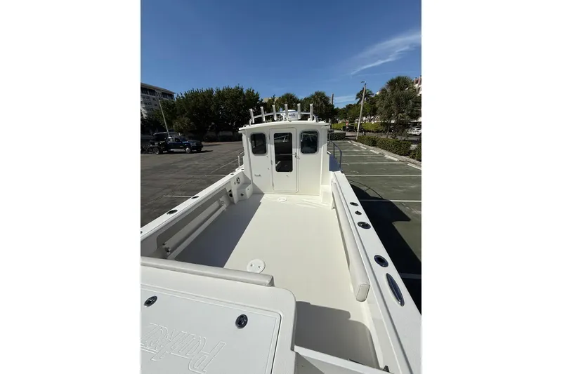 Slide: The Image of 2023 Parker 2320 Sport Cabin boat, spacious deck, parked outdoors under clear blue sky. - 28