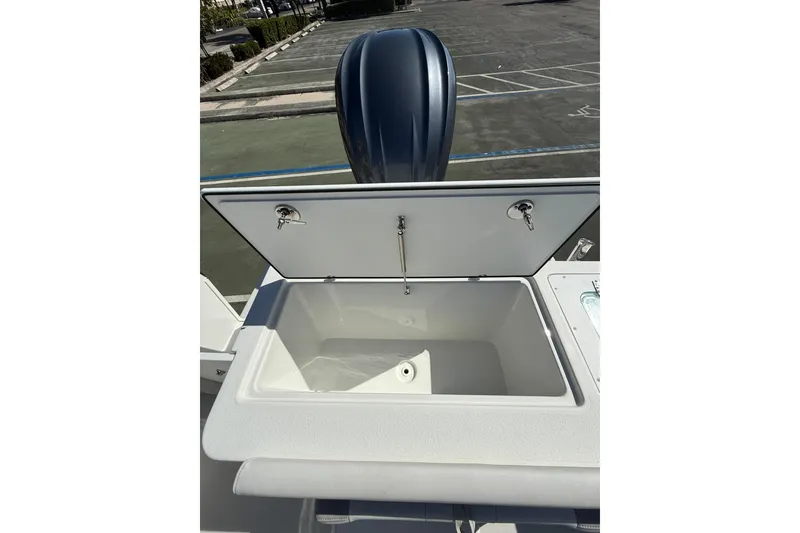 Slide: The Image of Open storage compartment on 2023 Parker 2320 Sport Cabin boat, with visible outboard motor. - 30