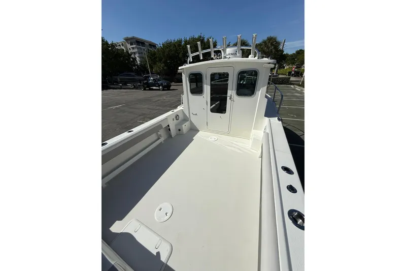 Slide: The Image of 2023 Parker 2320 Sport Cabin boat with spacious deck and cabin, parked outdoors. - 34