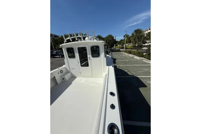 Slide: The Image of 2023 Parker 2320 Sport Cabin boat in parking lot, showcasing cabin and deck features. - 35