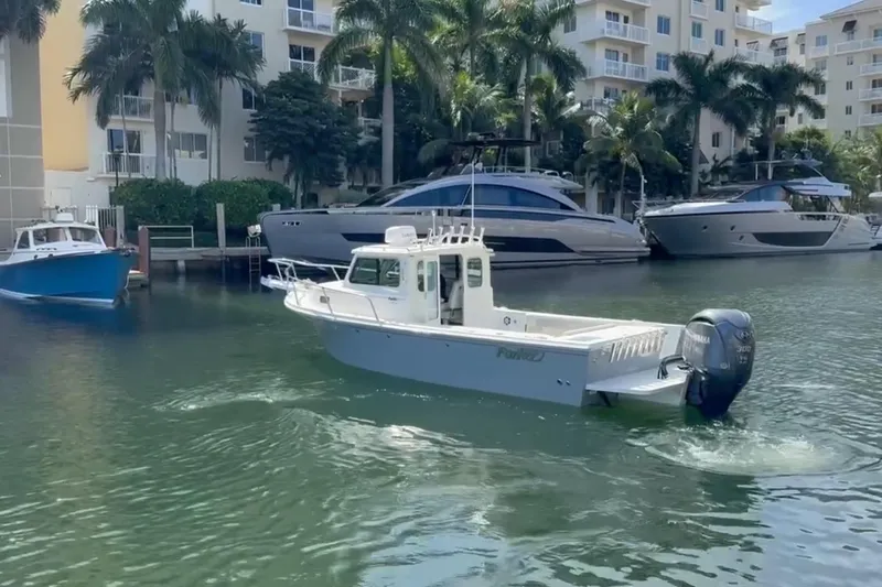 Slide: The Image of 2023 Parker 2320 Sport Cabin boat cruising in a marina with palm trees and yachts. - 4