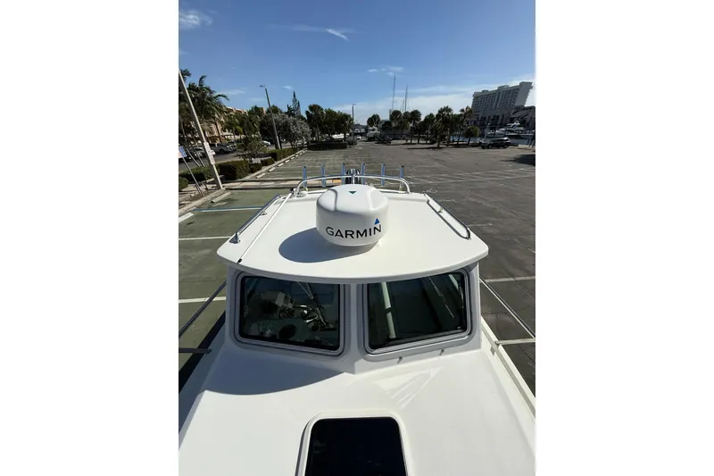 Slide: The Image of 2023 Parker 2320 Sport Cabin boat with Garmin radar, docked in a sunny marina. - 43