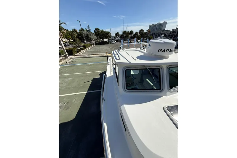 Slide: The Image of 2023 Parker 2320 Sport Cabin boat with Garmin equipment, docked in a sunny marina. - 45