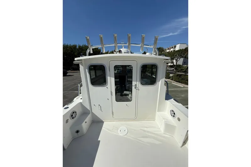 Slide: The Image of 2023 Parker 2320 Sport Cabin boat, rear view with rod holders and cabin doors. - 48