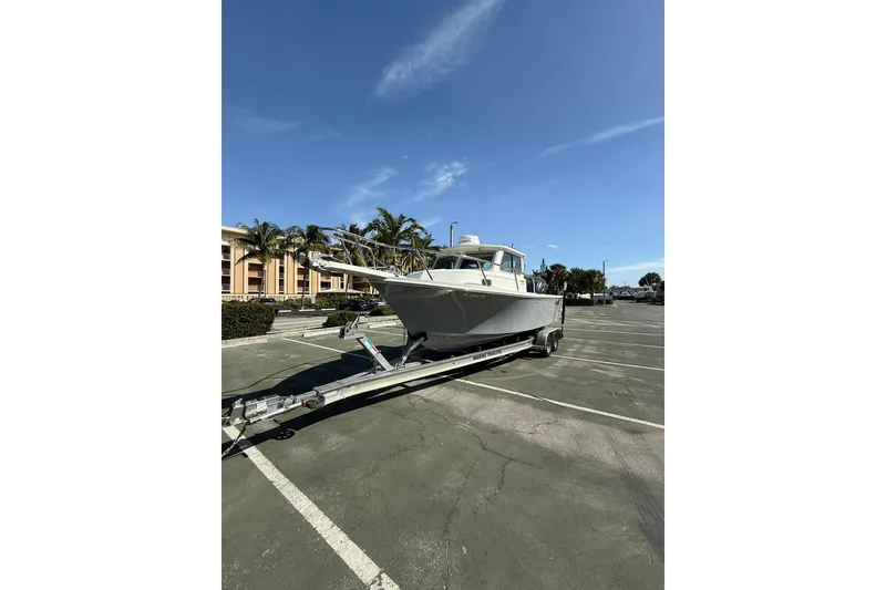 Slide: The Image of 2023 Parker 2320 Sport Cabin boat on trailer in sunny parking lot. - 5