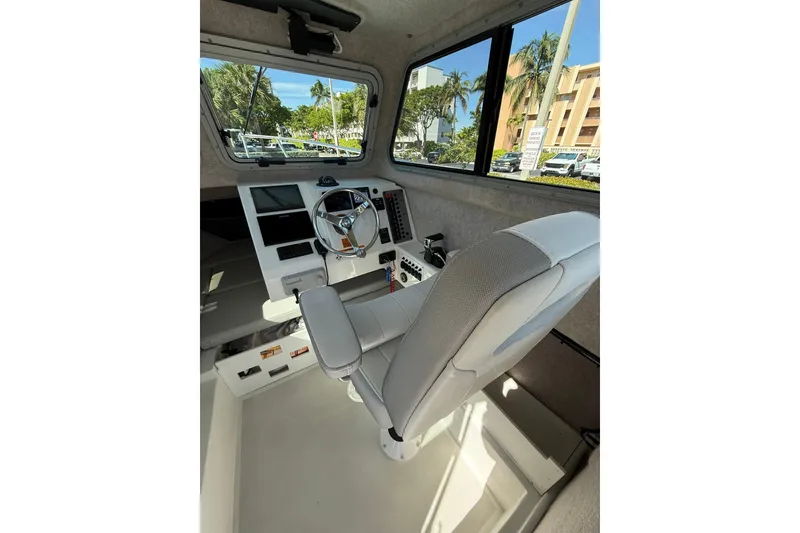 Slide: The Image of Interior of 2023 Parker 2320 Sport Cabin boat with steering wheel and captain's chair. - 51