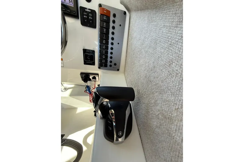 Slide: The Image of Control panel of 2023 Parker 2320 Sport Cabin boat with throttle and switches. - 61