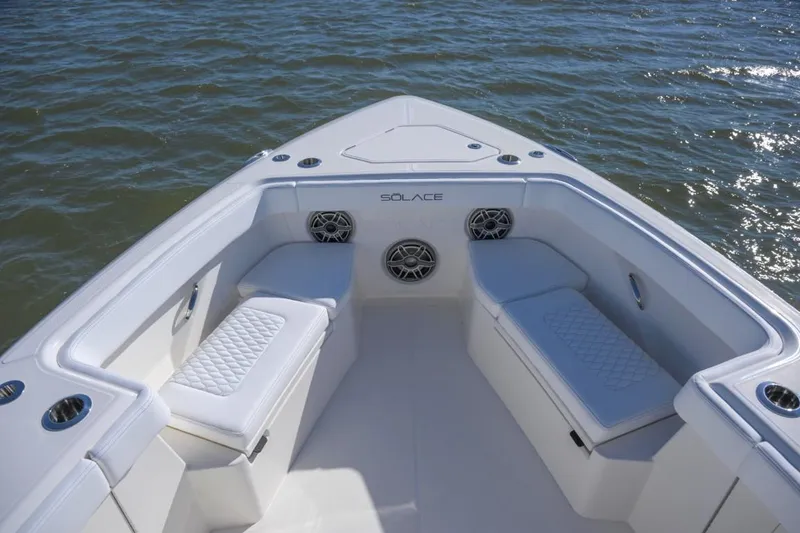 Slide: The Image of Manufacturer Provided Image: 2026 Solace 37 CS boat interior with cushioned seating and speakers on calm water. - 2