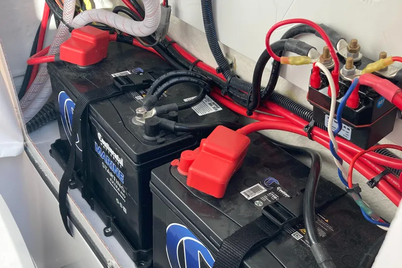 Slide: The Image of 2023 Sportsman Open 242 Center Console boat battery compartment with wiring and connections. - 20