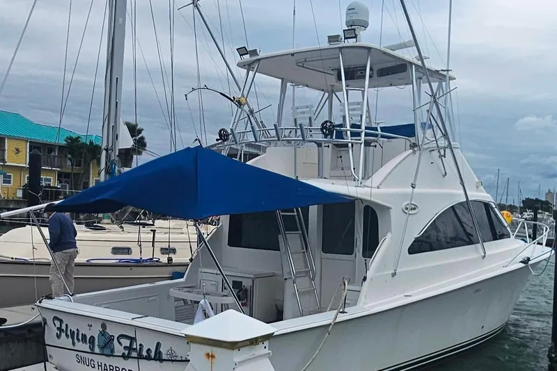 Slide: The Image of 2000 Ocean Yachts 40 Super Sport docked, featuring a blue canopy and sleek design. - 1