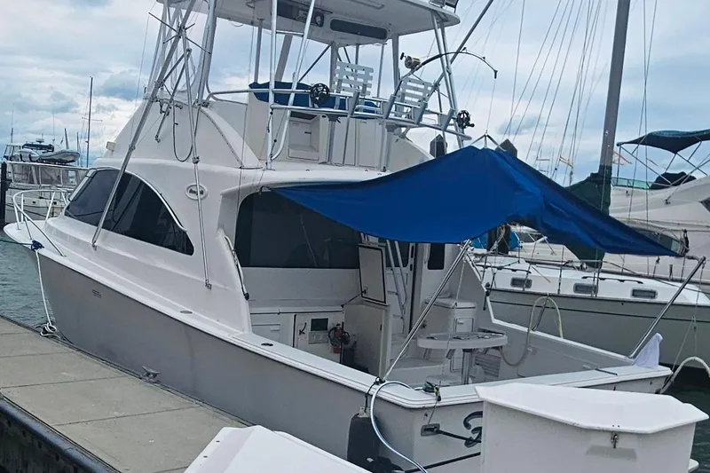 Slide: The Image of Ocean Yachts 40 Super Sport 2000 docked, featuring a blue canopy and spacious deck. - 2