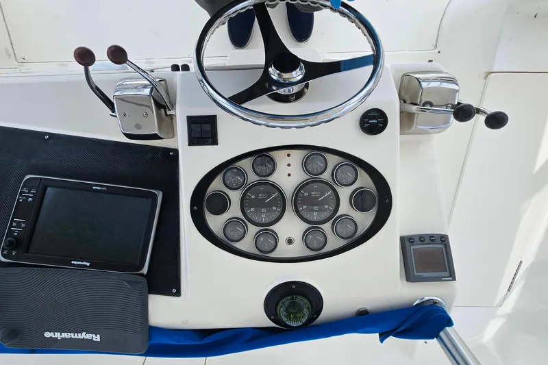 Slide: The Image of Control panel of a 2000 Ocean Yachts 40 Super Sport with steering wheel and navigation instruments. - 28