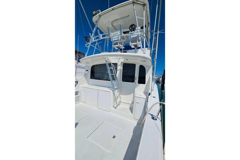 Slide: The Image of 2000 Ocean Yachts 40 Super Sport boat with flybridge and ladder, docked under clear blue sky. - 97