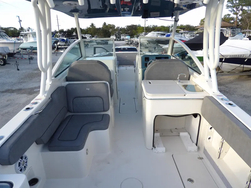 Slide: The Image of 2022 Stingray 269 DC boat interior with seating and helm, docked at marina. - 12