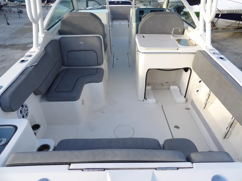 Slide: The Image of 2022 Stingray 269 DC boat interior with gray seating and compact kitchenette. - 13