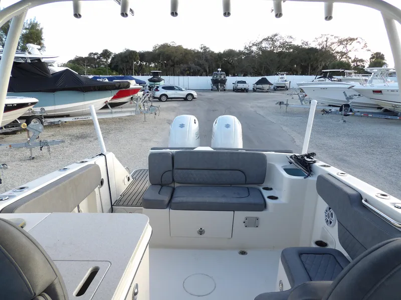 Slide: The Image of 2022 Stingray 269 DC boat interior with dual engines, docked in a marina. - 14