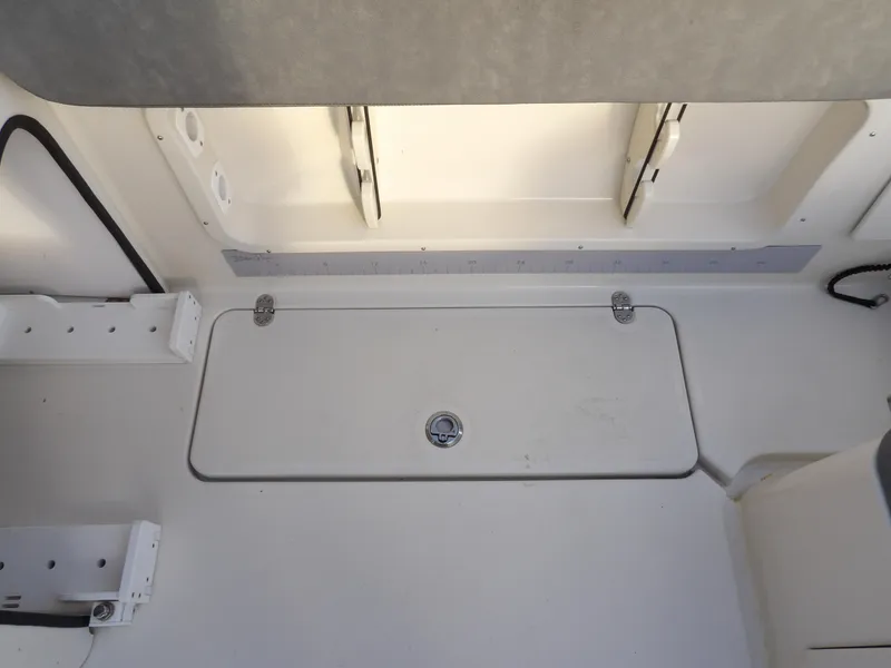 Slide: The Image of 2022 Stingray 269 DC boat interior storage compartment with hinged lid. - 21
