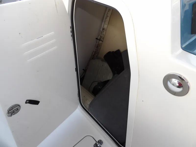 Slide: The Image of 2022 Stingray 269 DC boat storage compartment with open door, showcasing interior space. - 43