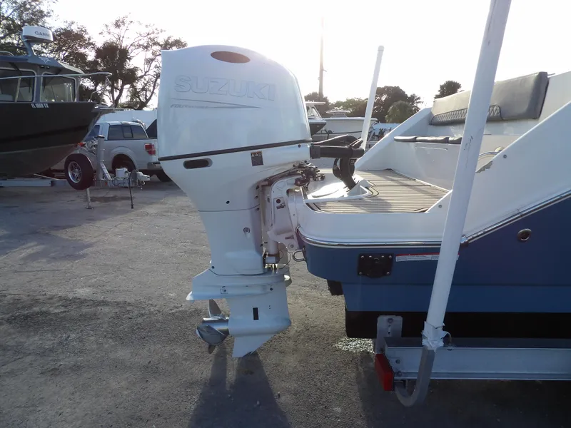 Slide: The Image of 2022 Stingray 269 DC boat with Suzuki outboard motor, parked on a trailer. - 9