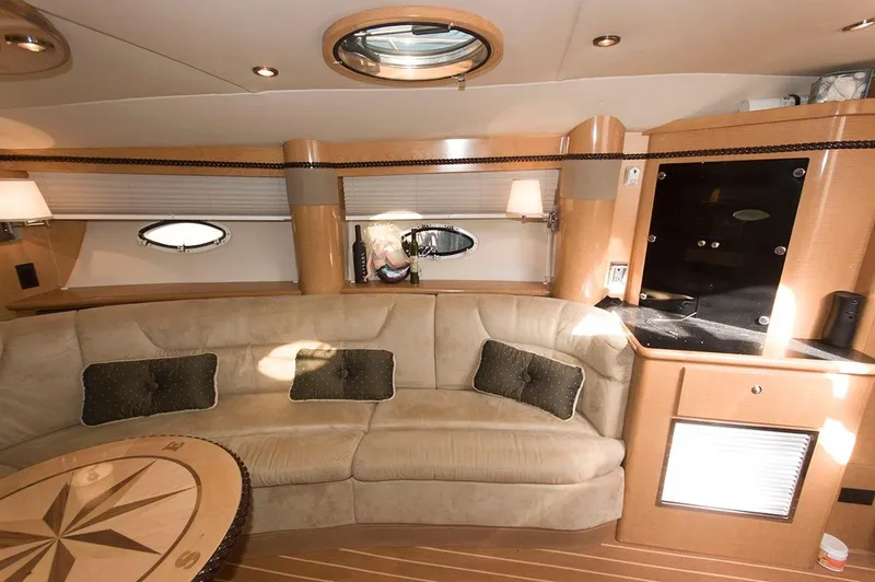 Slide: The Image of Interior of 2009 Larson Cabrio 330 Day Cruiser with beige sofa and wooden table. - 13