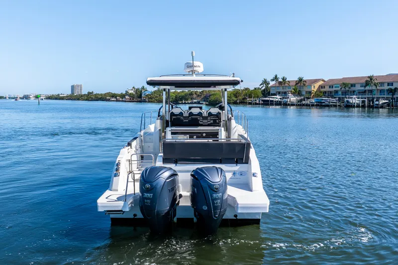 Slide: The Image of 2024 Jeanneau Leader 10.5 WA Series 2 boat on calm water, rear view. - 12