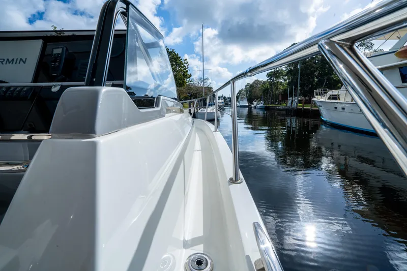 Slide: The Image of 2024 Jeanneau Leader 10.5 WA Series 2 boat on a calm waterway under a cloudy sky. - 28