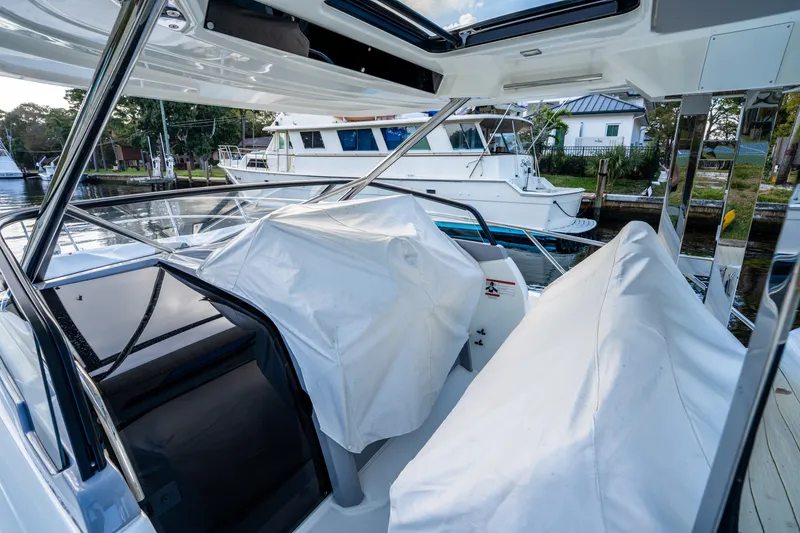 Slide: The Image of 2024 Jeanneau Leader 10.5 WA Series 2 boat docked, covered seating area visible. - 31