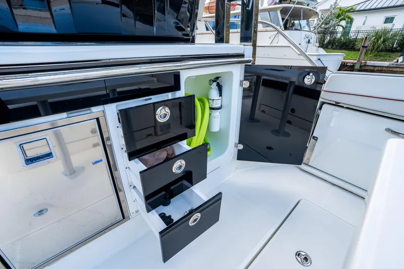 Slide: The Image of 2024 Jeanneau Leader 10.5 WA Series 2 boat interior with storage drawers and mini fridge. - 60