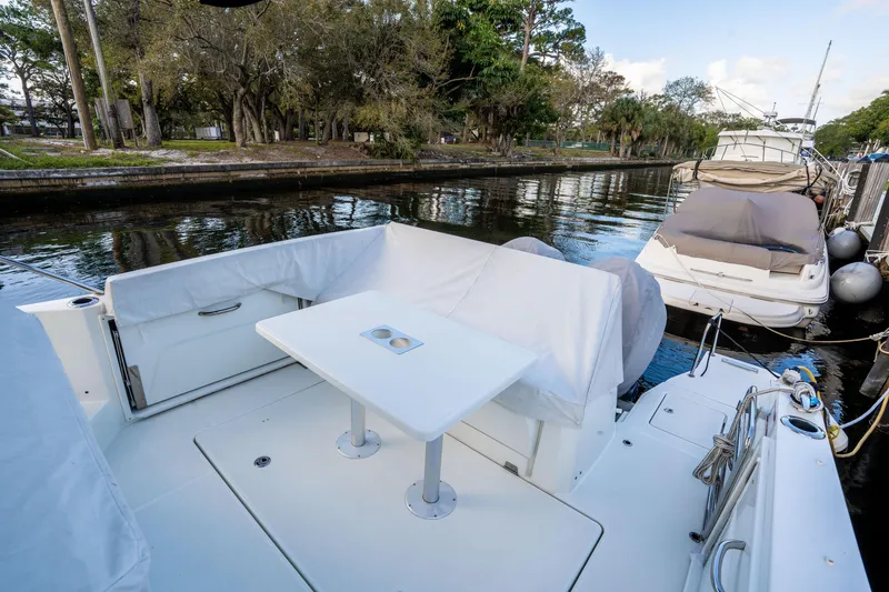 Slide: The Image of 2024 Jeanneau Leader 10.5 WA Series 2 boat docked, featuring a covered seating area and table. - 61