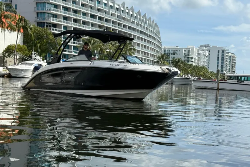 Slide: The Image of 2021 Sea Ray SDX 290 Outboard boat on water near modern buildings. - 11