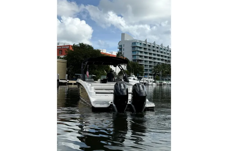 Slide: The Image of 2021 Sea Ray SDX 290 Outboard boat docked in marina, with twin engines visible. - 15