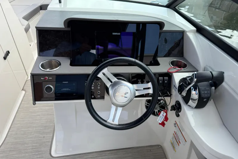 Slide: The Image of 2021 Sea Ray SDX 290 Outboard helm with steering wheel, controls, and display panel. - 23
