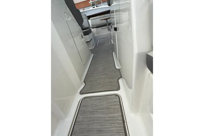 Slide: The Image of 2021 Sea Ray SDX 290 Outboard interior walkway with sleek design and modern flooring. - 24